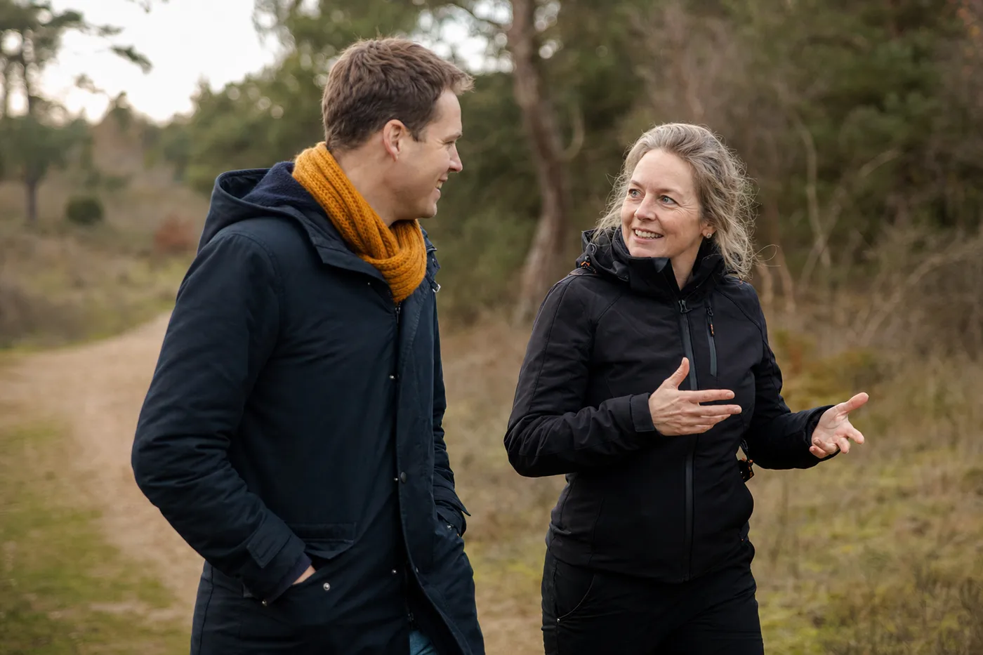 Medewerker wandelt energiek buiten tijdens een coachgesprek