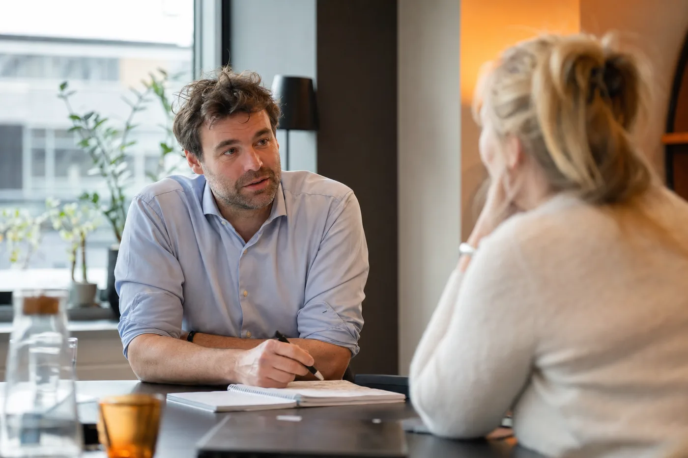 Twee collega's in een open gesprek aan een tafel