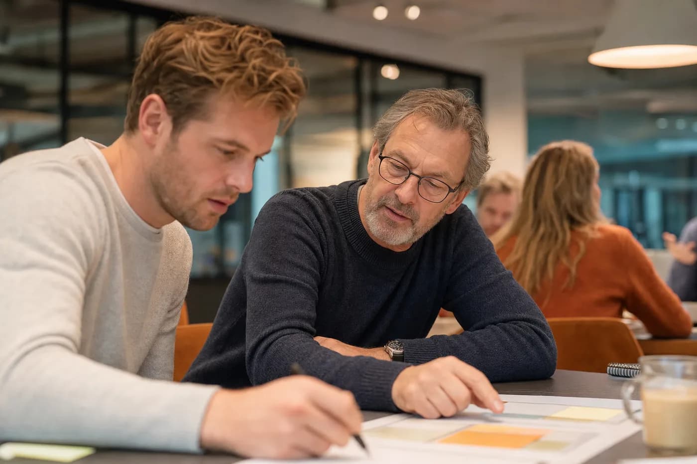 Jonge en oudere collega's werken samen aan een opdracht