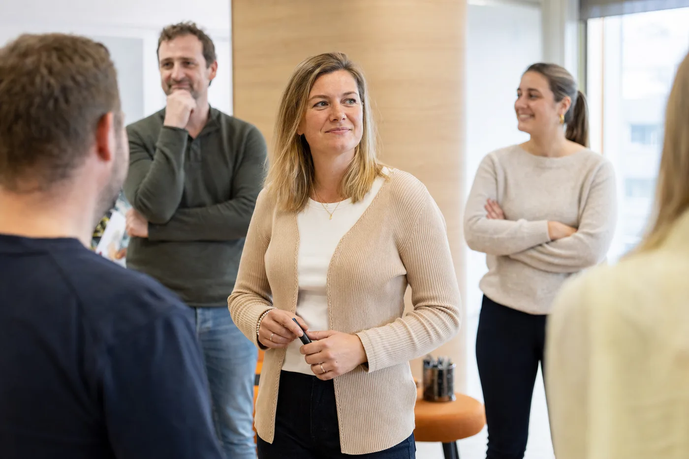 Professional staat zelfverzekerd in een lichte werkruimte